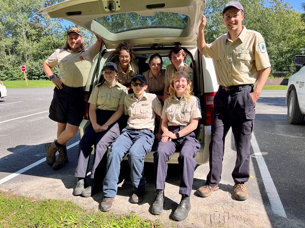 group of staff sitting on trunk of van