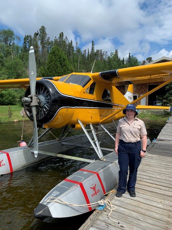 staff standing in front of float plane