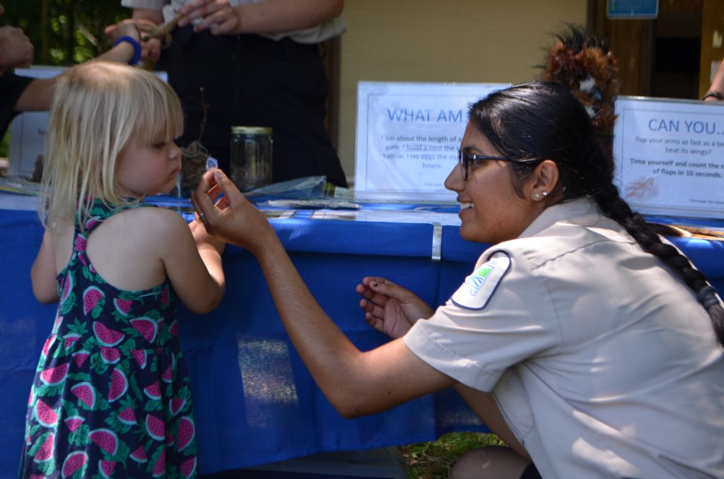 staff showing item to child at exploration station