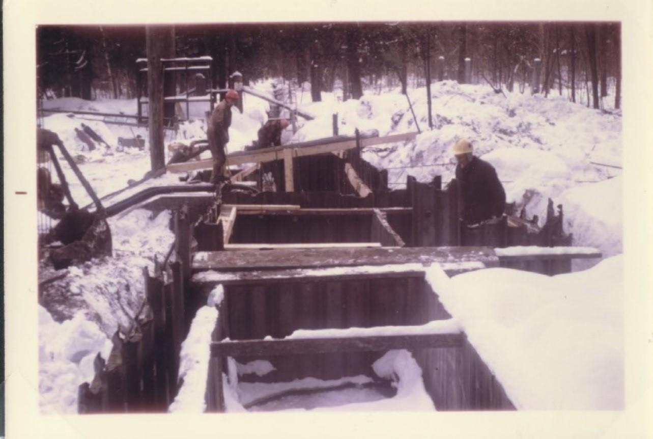 historical photo of men working over trough