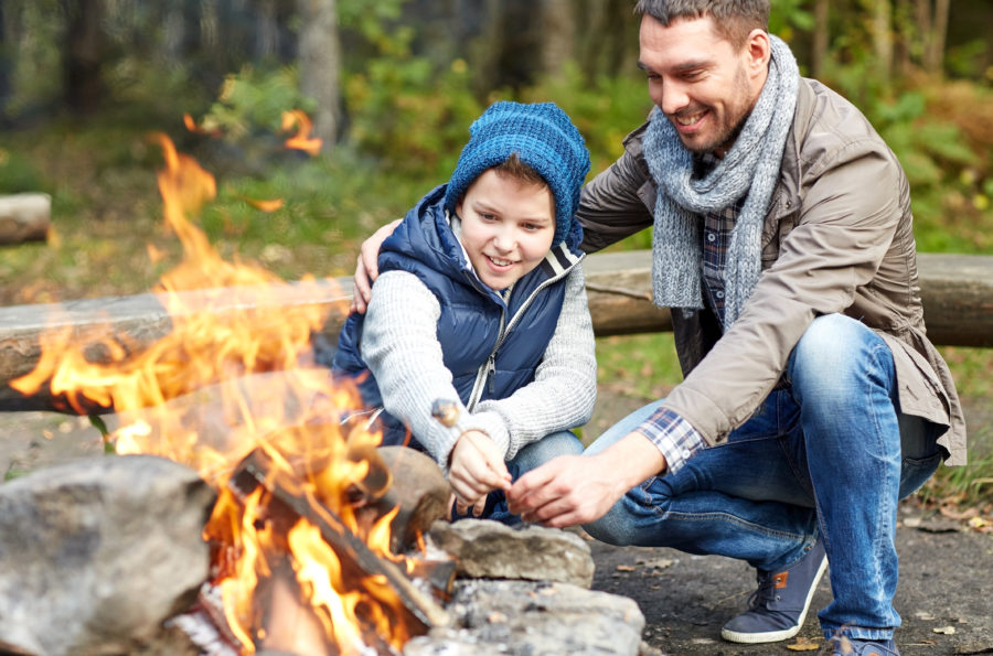 father and son roasting marshmallows