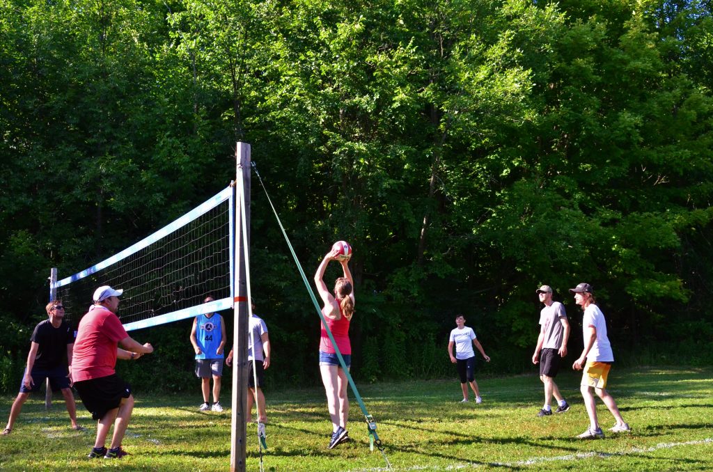 group playing volleyball on grass