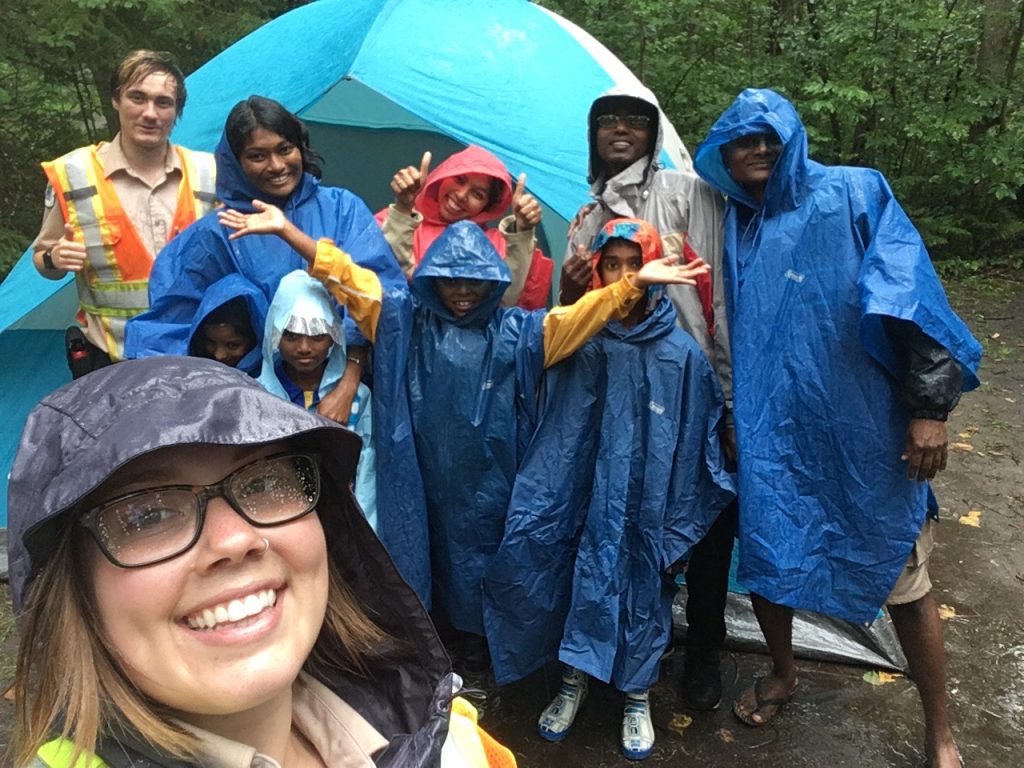 Group of campers in rain ponchos with park staff