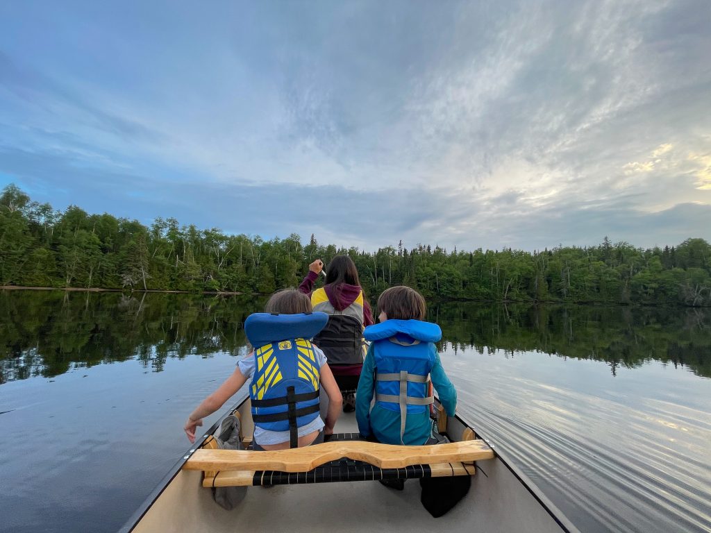 A family paddling in a canoe across a lake