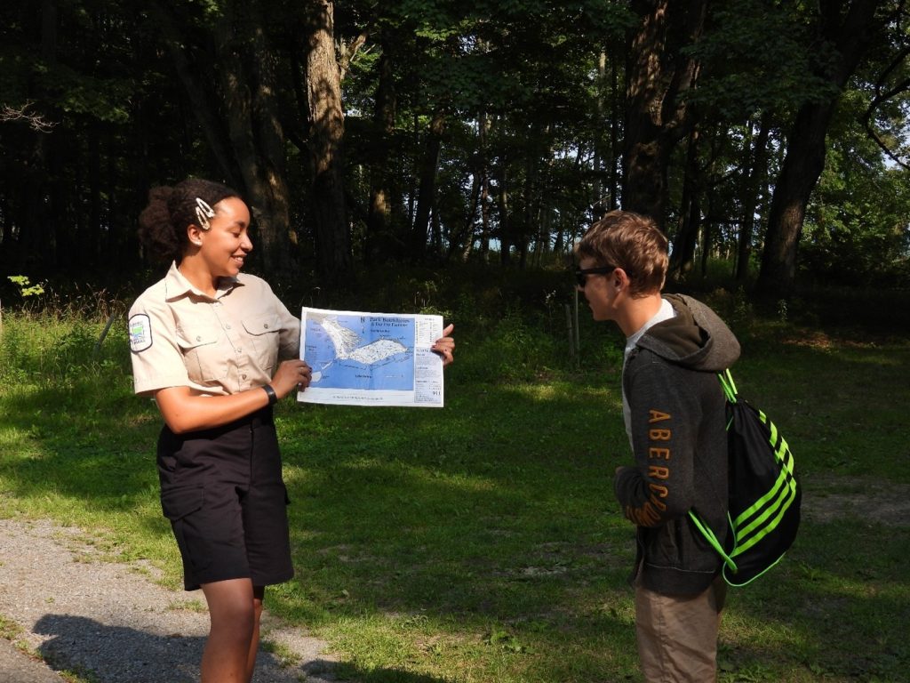 staff showing park tabloid to visitor