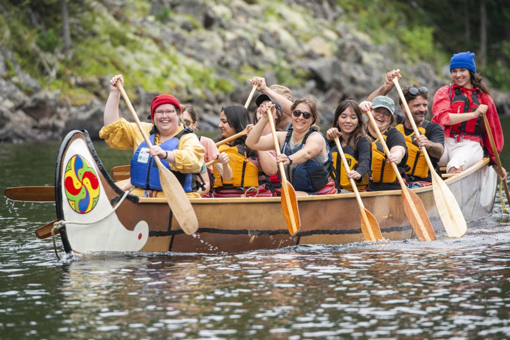 visitors paddling in voyageur-style canoe