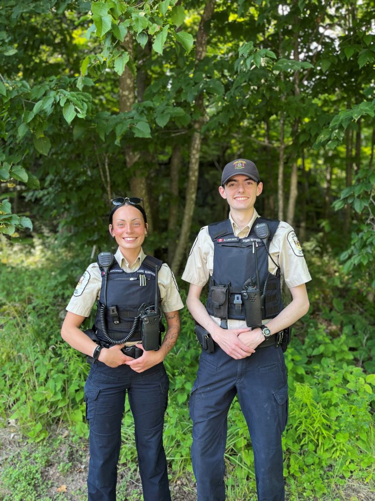 Ellen and Alexis standing in front of forest