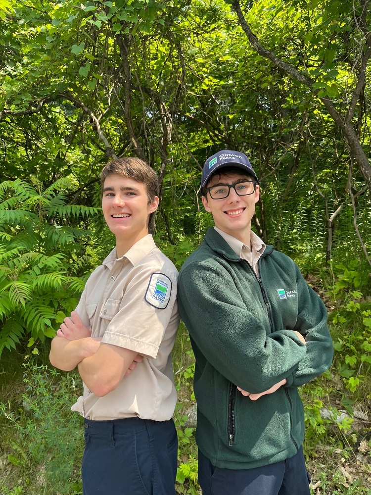 two staff standing back-to-back 