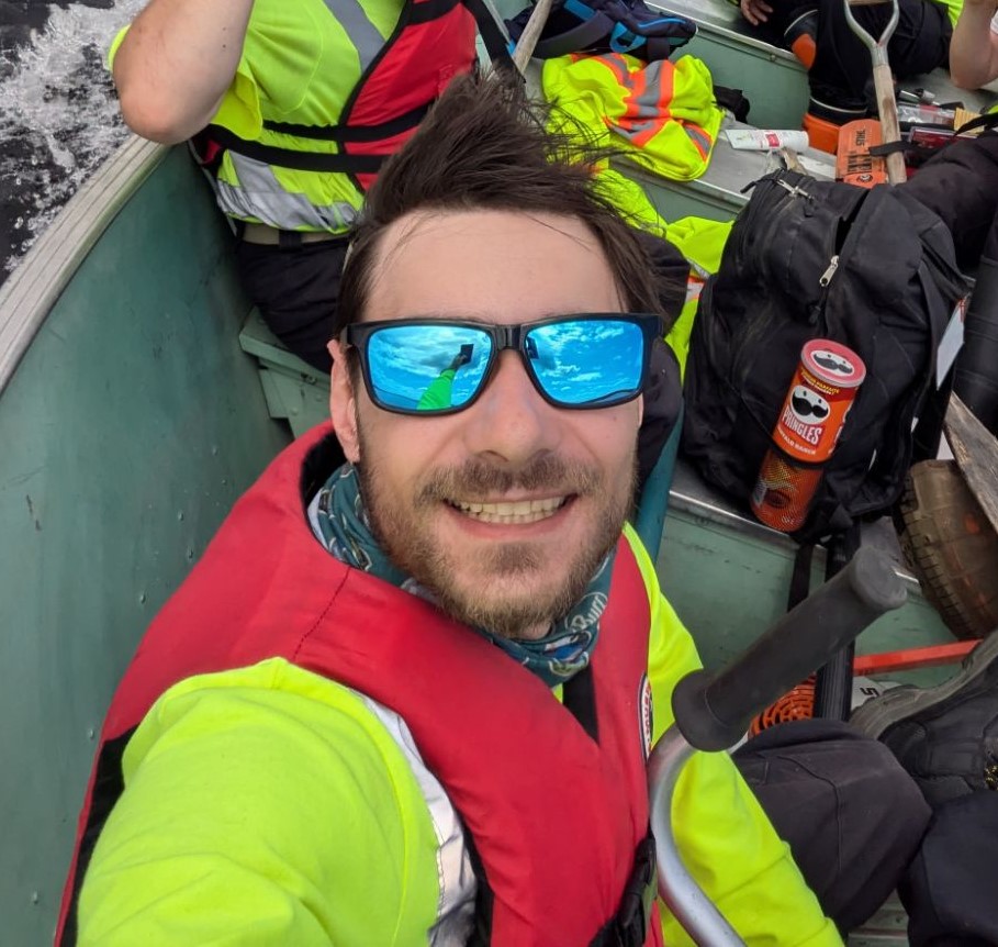 staff taking selfie, wearing sunglasses on boat