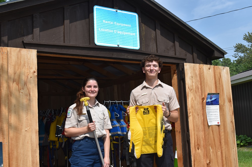 two staff holding paddling equipment