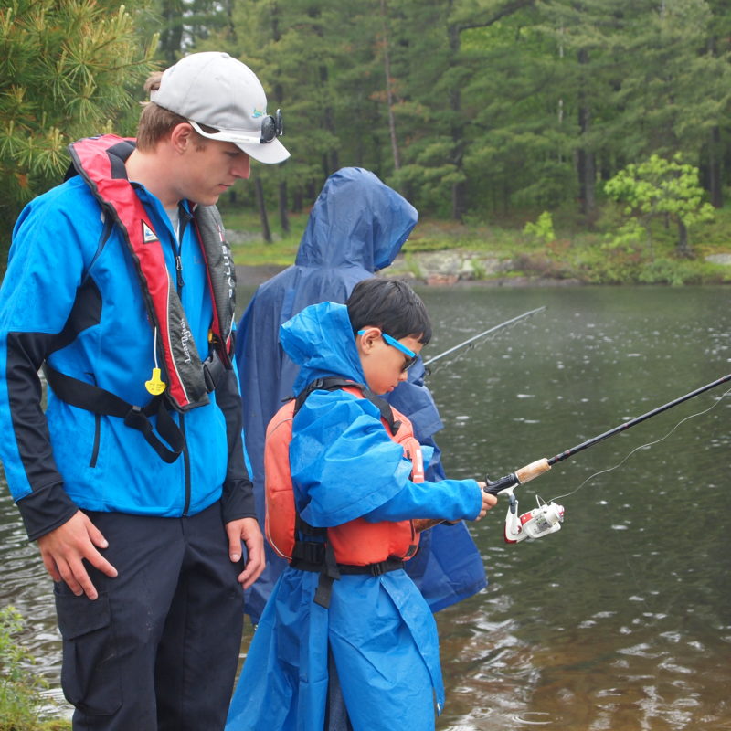 Nate teaching boy to fish