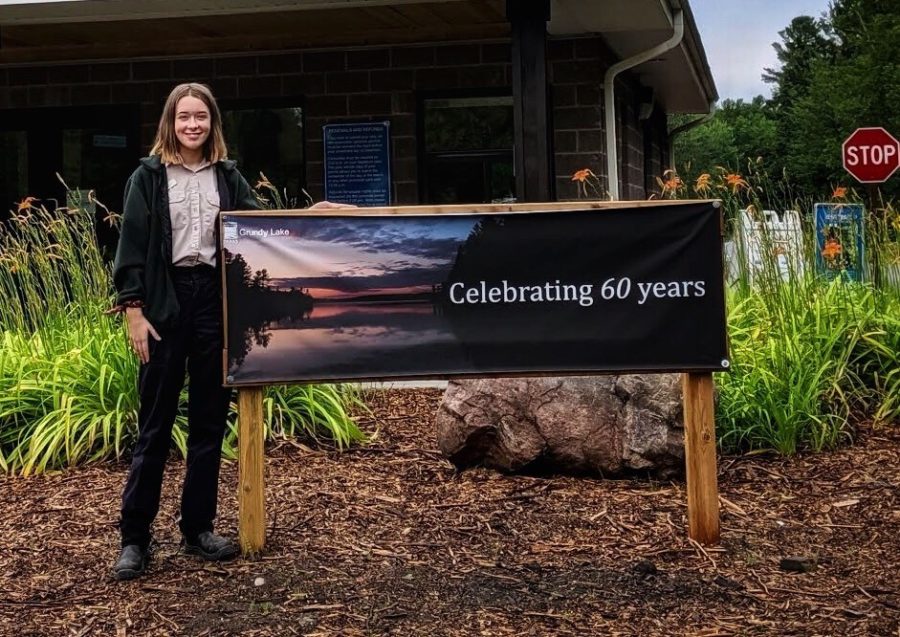 park staff standing in front of sign