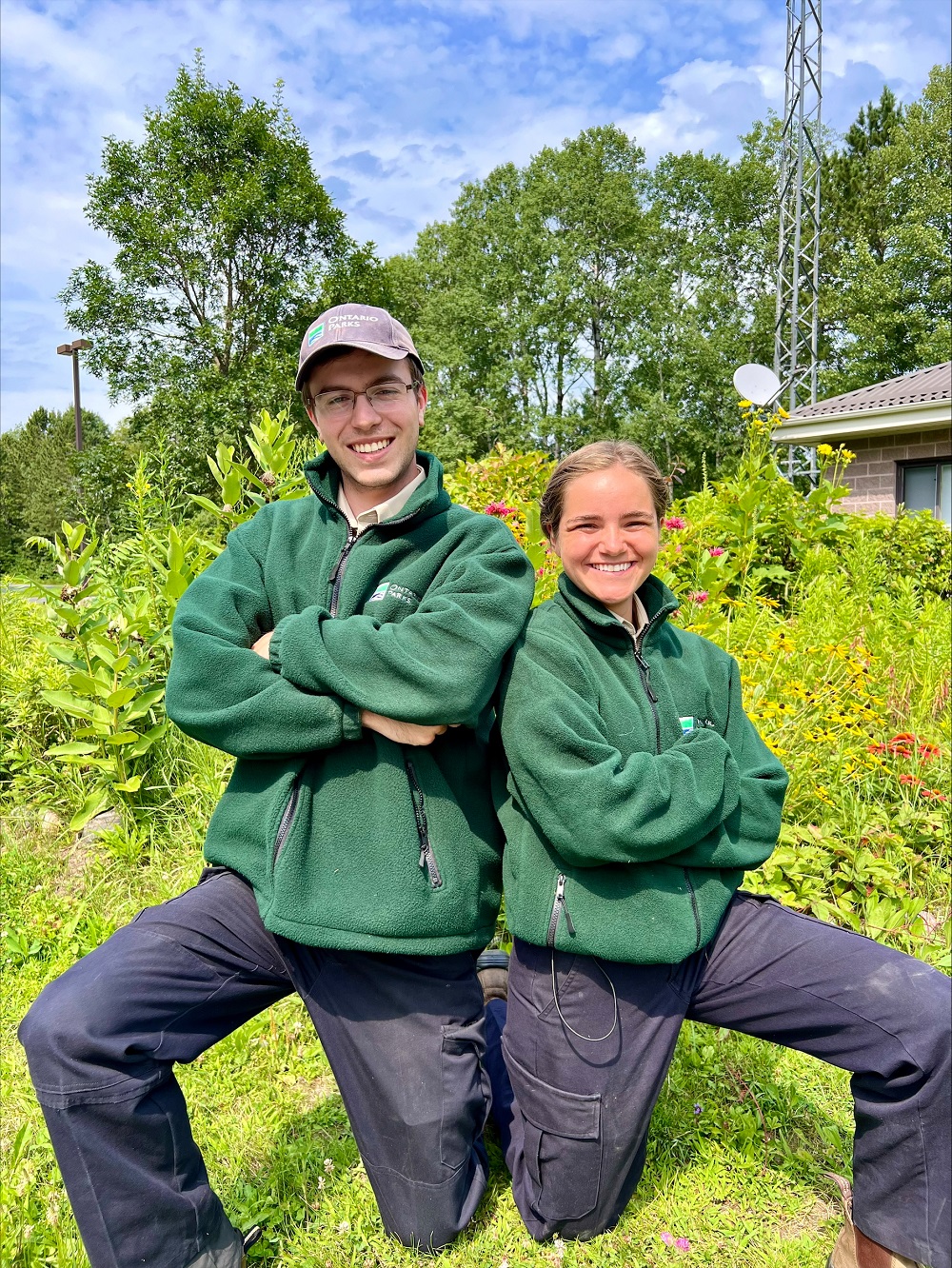 two staff, each on one knee and arms crossed