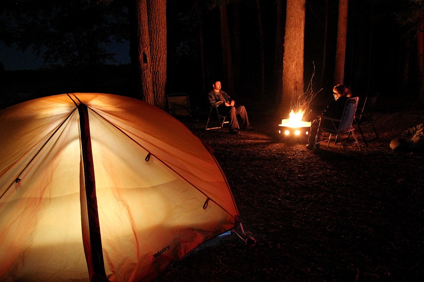 group sitting on campsite at night