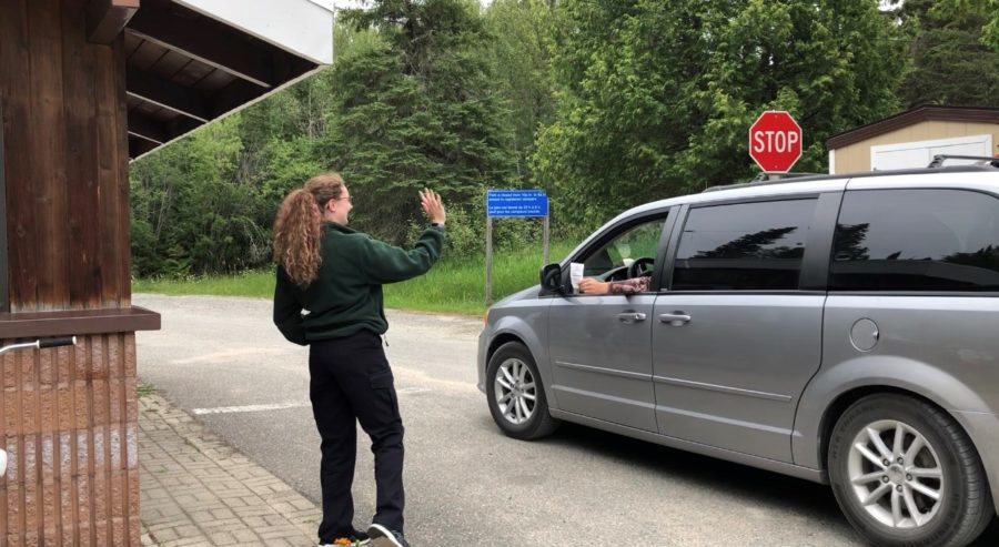 student waving to camper