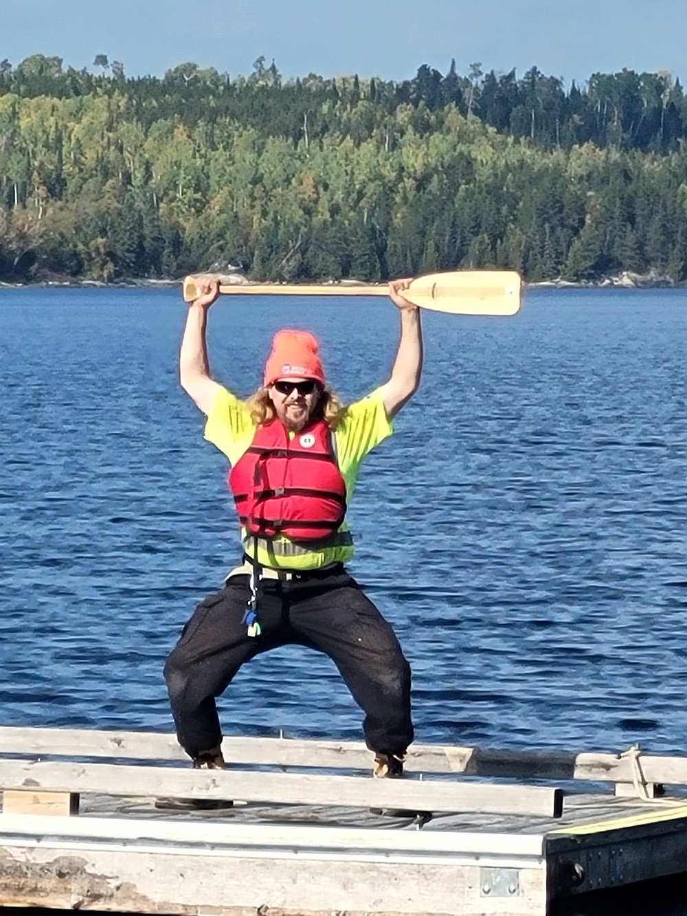 staff holding paddle, standing on dock