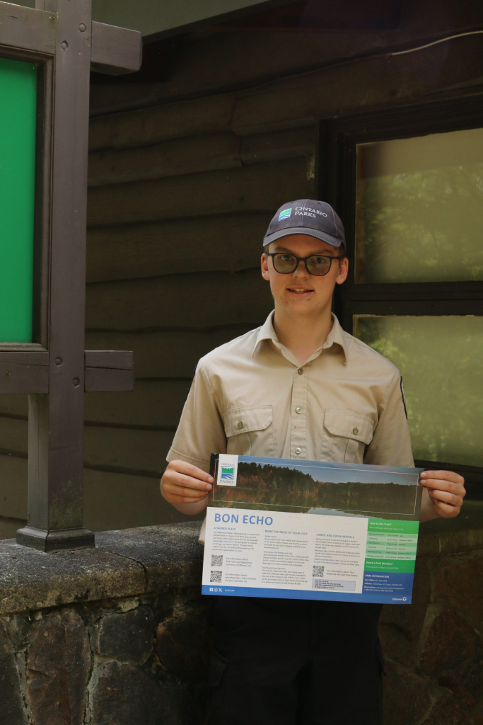 Michael tenant une page d’information sur le parc provincial Bon Echo
