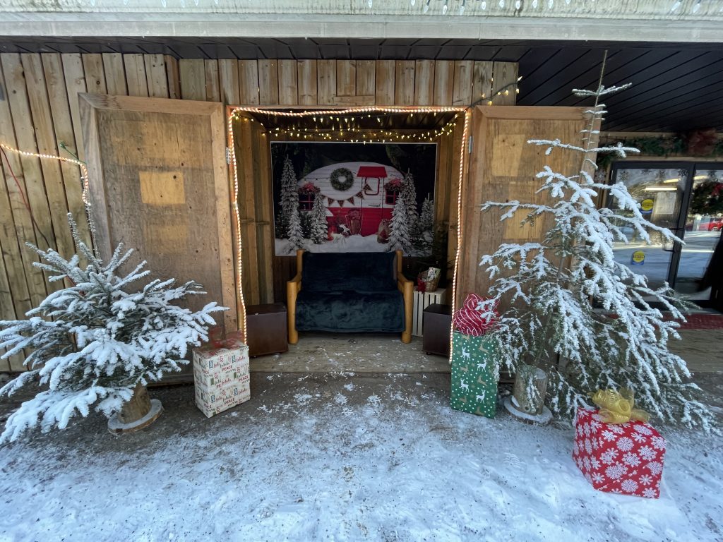 A tiny "meet Santa" area decorated with holiday trees and gifts