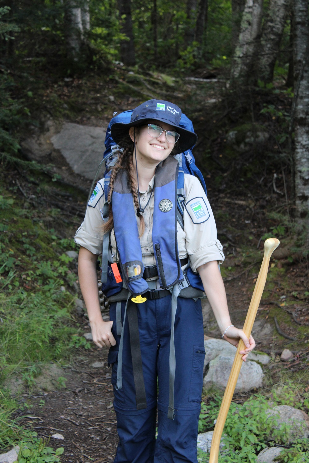 staff wearing uniform, PFD, holding paddle