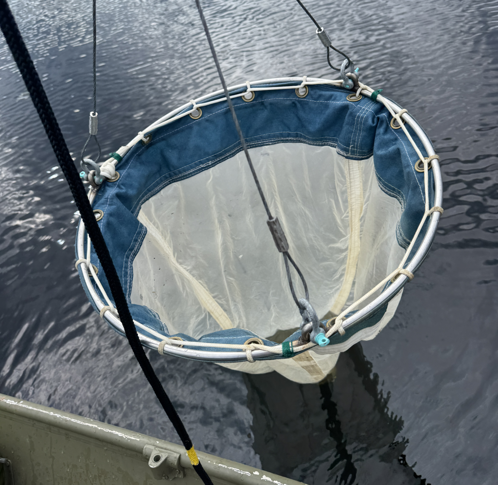 big sampling net being raised from the water into a boat
