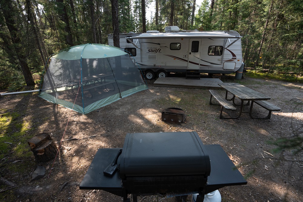 trailer, screened shelter. and barbecue