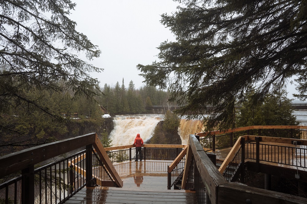 person standing at lookout looking at falls