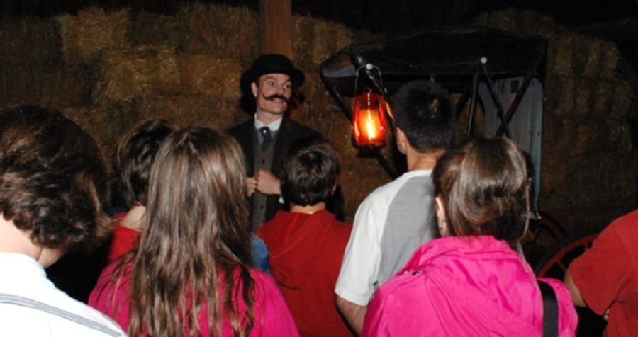 Guide dressed in victorian clothes talks to crowd about the house.