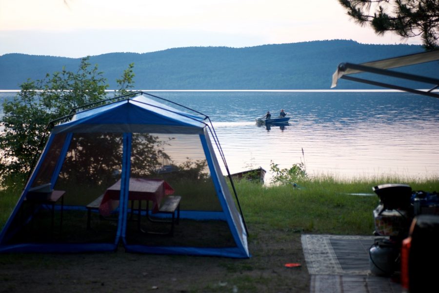 Waterfront trailer site with boat in background 