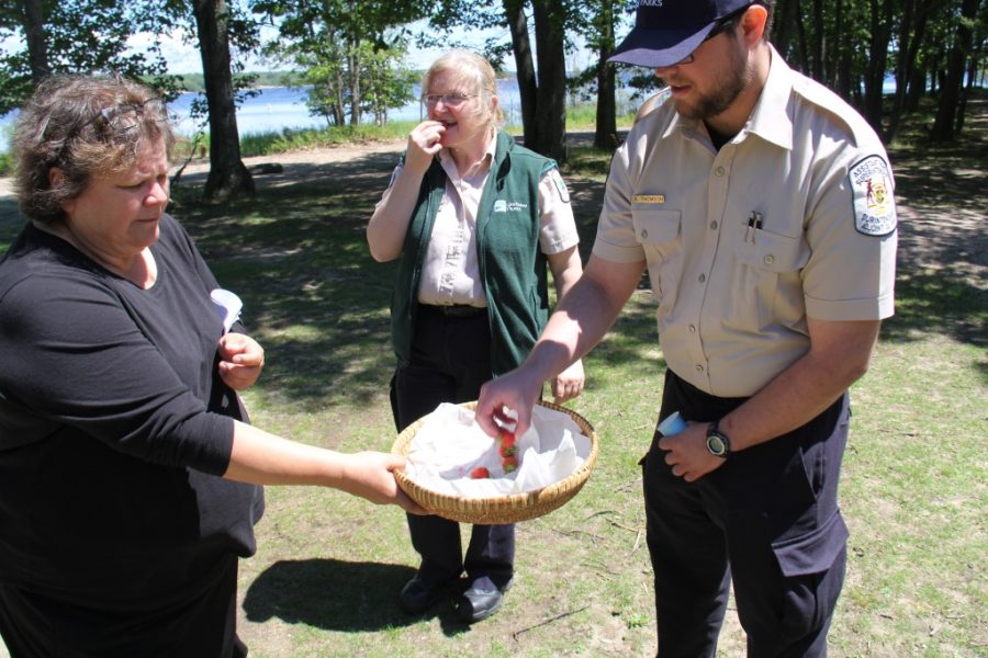 staff and community member share strawberries