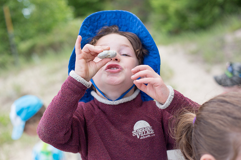 Child holds up small rock he found