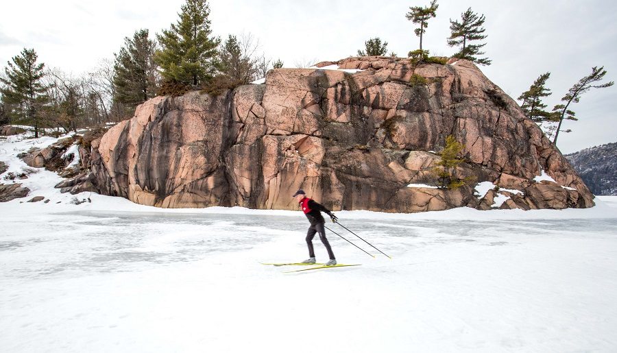 Man skiing past granite