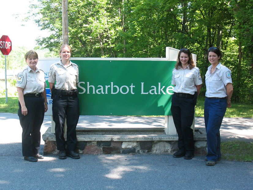 Four women stand by park sign