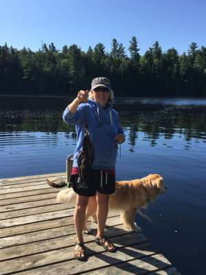 Sandy holding fish on dock