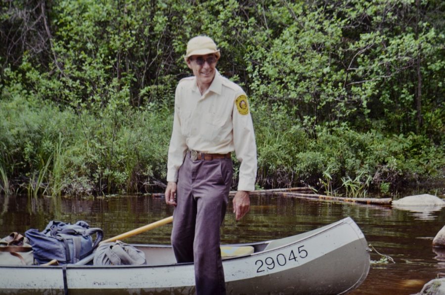 Park Warden stepping out of canoe with a bright yellow crest on this shoulder