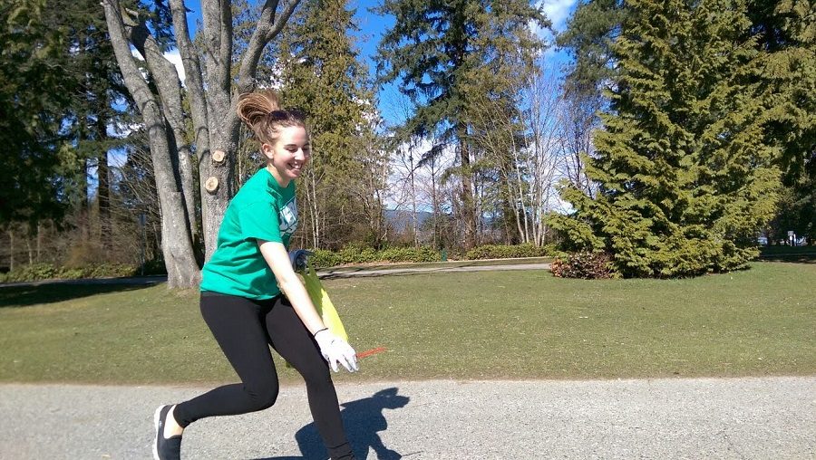 Woman pauses during jog to pick up trash