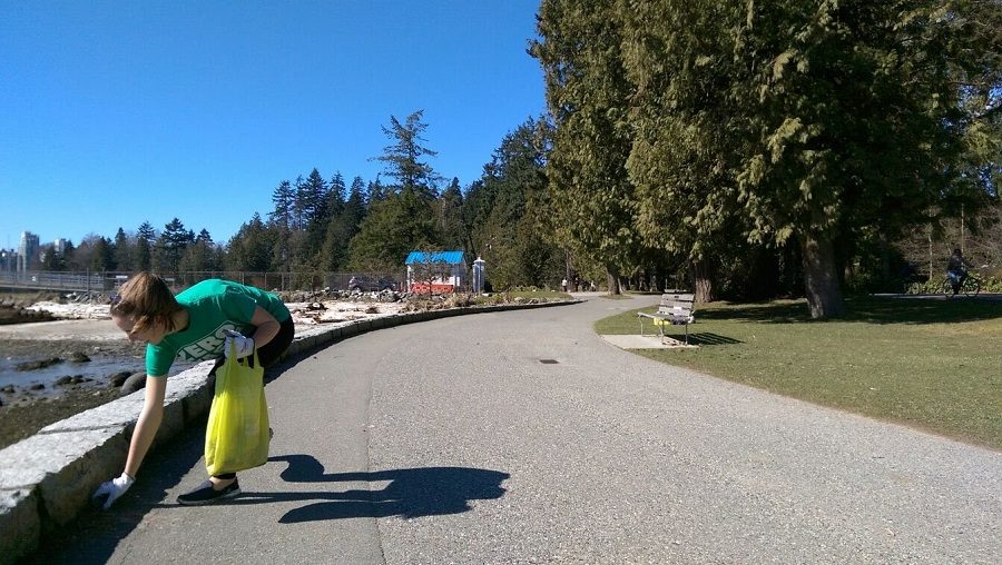 Woman bends down to pick up trash