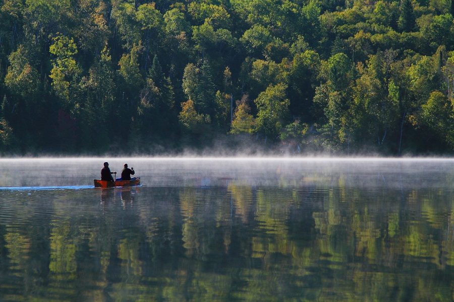 Canoe paddles in the distance on foggy morning