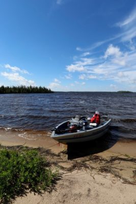 Motorboat on a sandy beach with a blue sky overhead