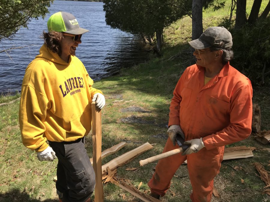 two men holding wooden materials