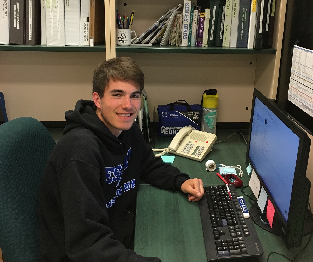 Daniel seated in an office at a computer, smiling