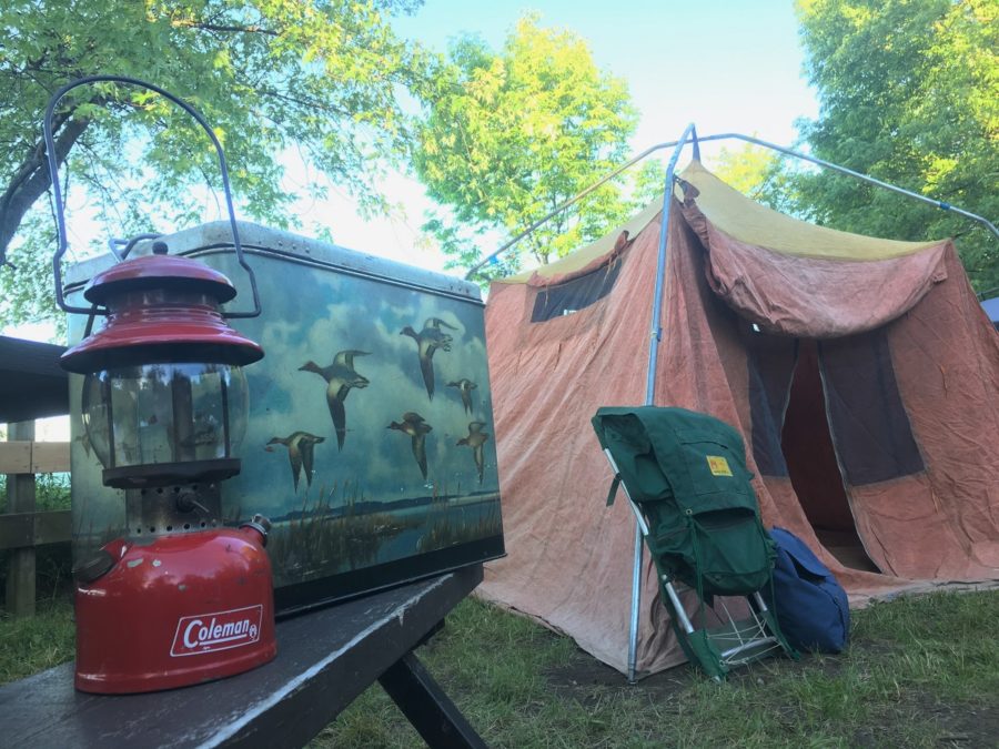 Colman lantern with vintage cooler in the foreground with big orange tent in the background