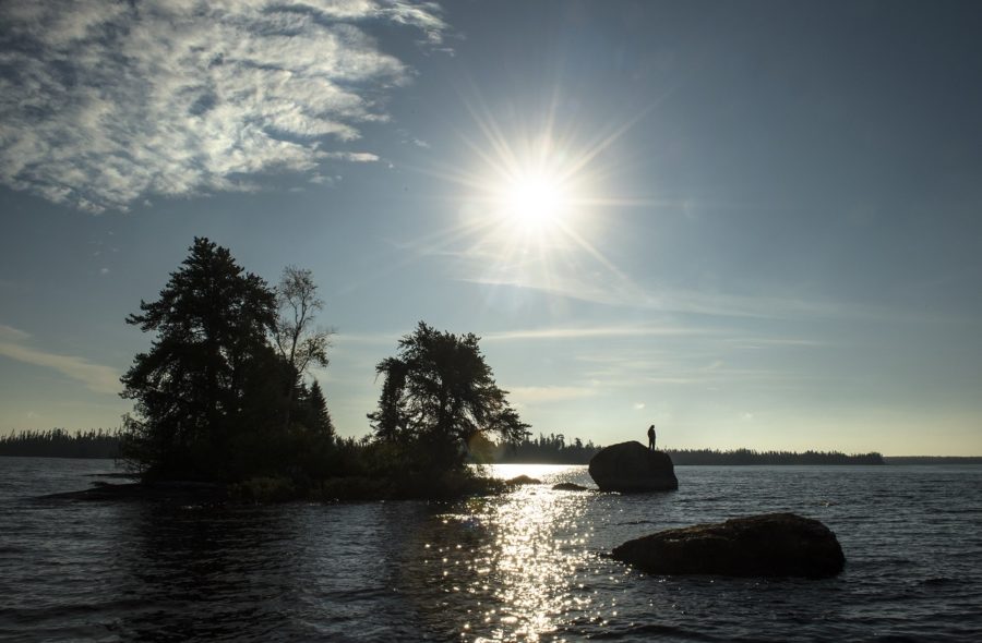 Sun shining brightly over lake with rock islands