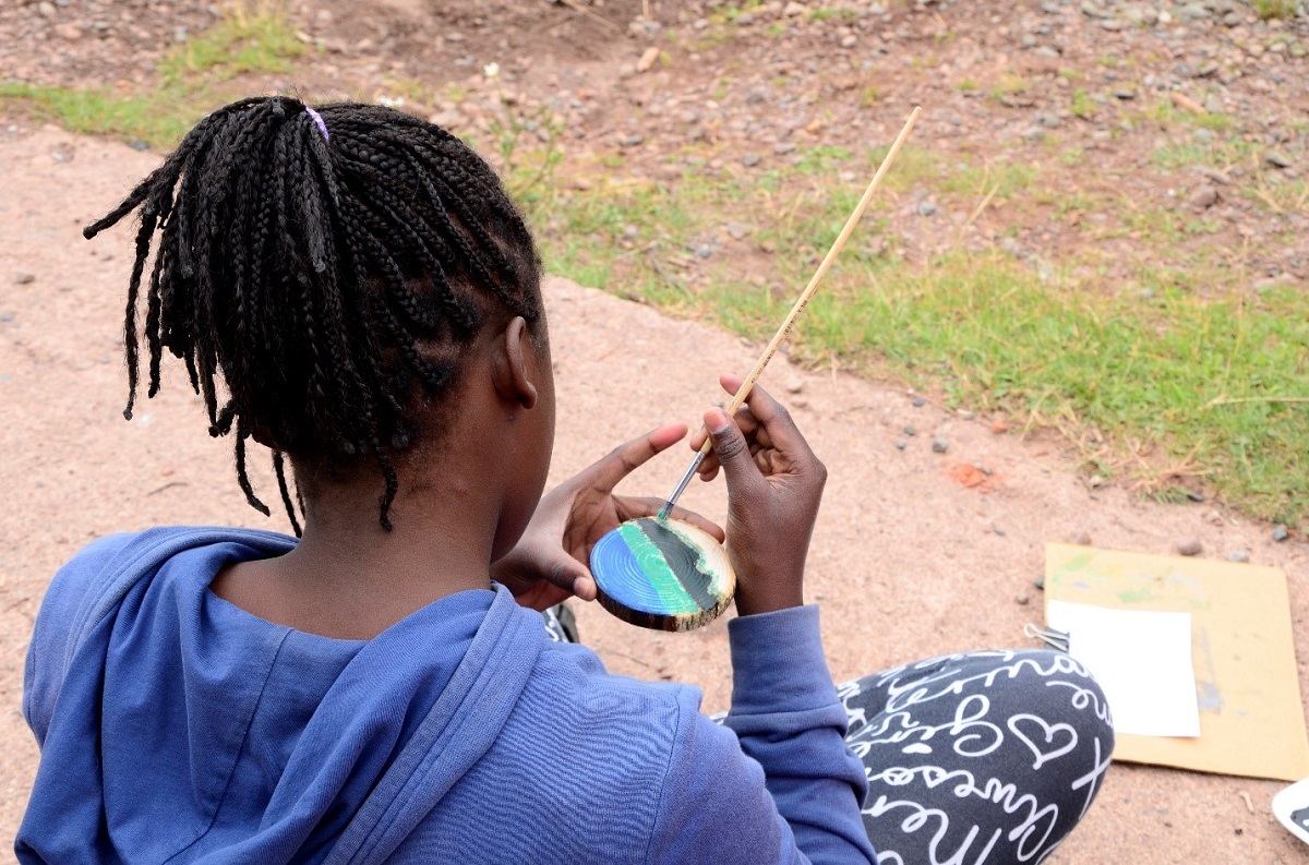 Behind a girl painting on a cookie