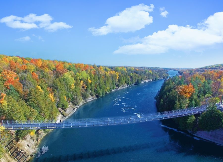 Fall landscape with river and walking bridge across