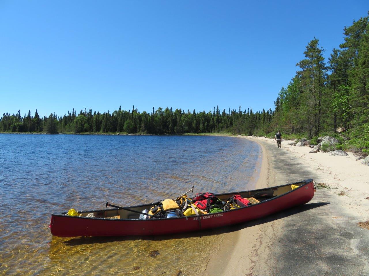 Canoe filled with gear, up on the shore of a beach