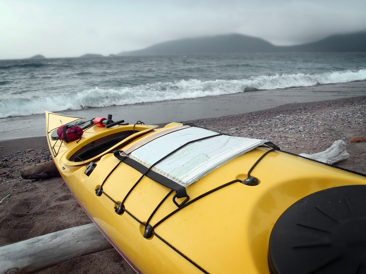 Yellow kayak on the shore of a lake with a big storm overhead