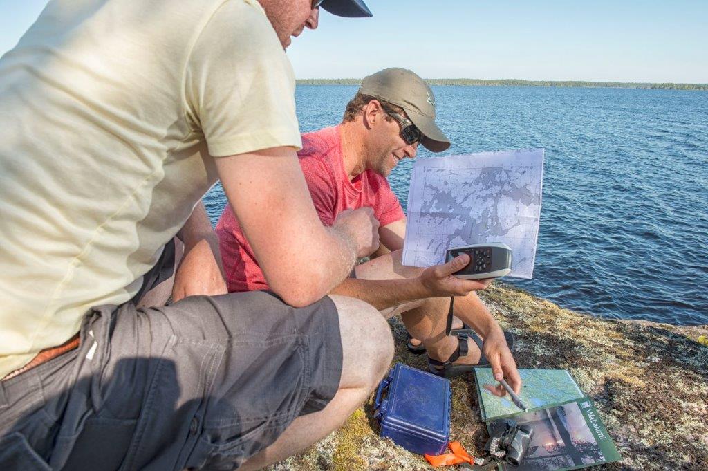 Two guys looking at a map with their orienteering equipment out