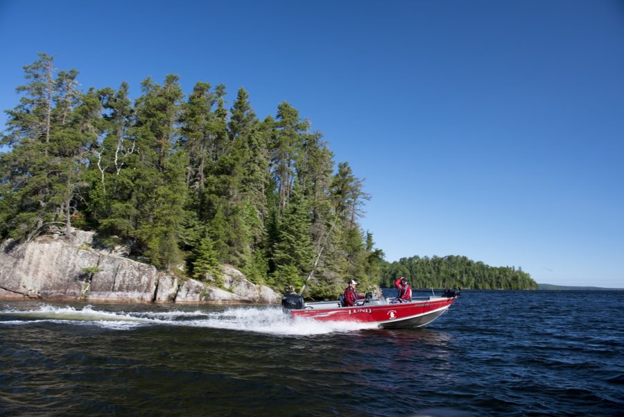 Couple of people, zipping around Wakami Lake in a red motor boat on a clear sky sunny day