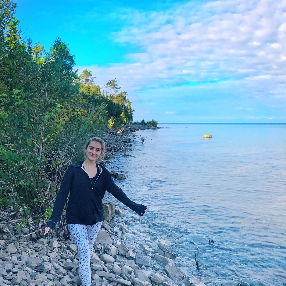 Woman in black shirt on a shoreline when sun is low in the sky