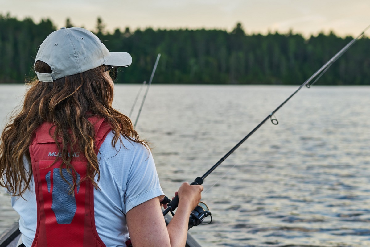 Back shot of a woman fishing in a lake